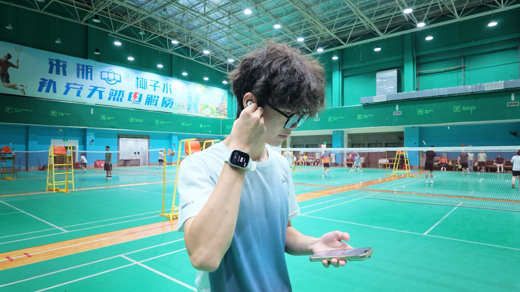 AirPods, Apple Watch and iPhone in use together at a badminton hall